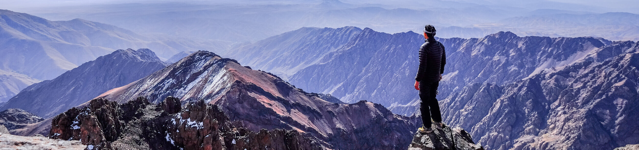 A hiker standing on top of the mountains