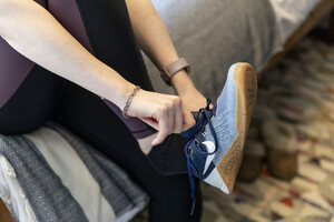 A woman putting on running shoes 