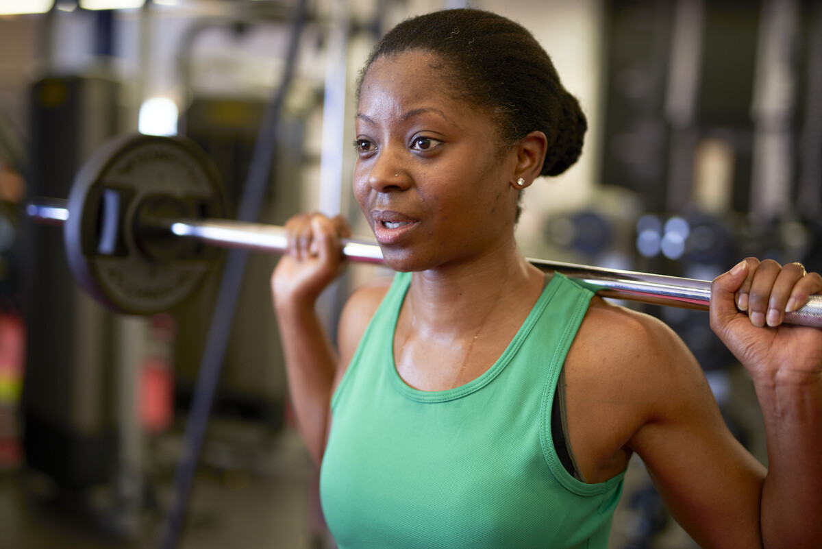 A female lifts weights in a gym