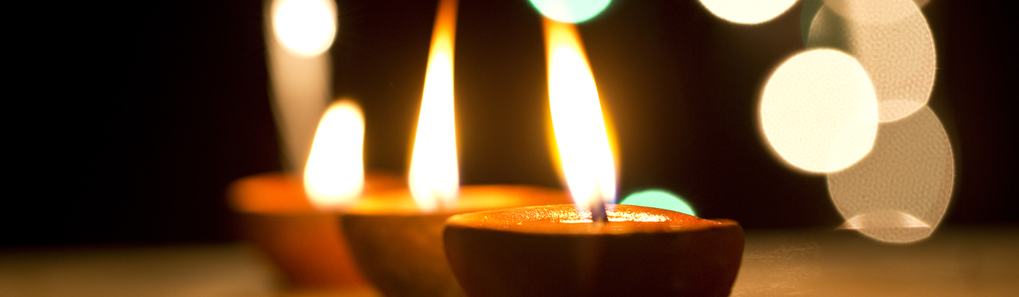 Three candles are lit for a Diwali celebration.