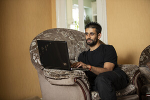 Amuz using his laptop while sitting in his living room