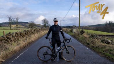 Sir Chris Hoy standing with his bike on the road