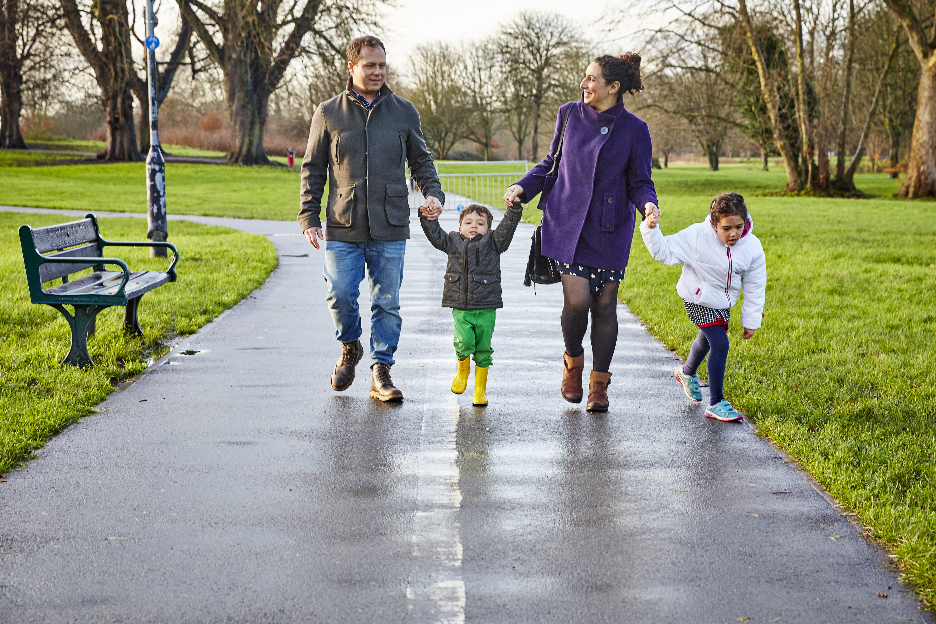 A family walking in the park on a sunny winter's day