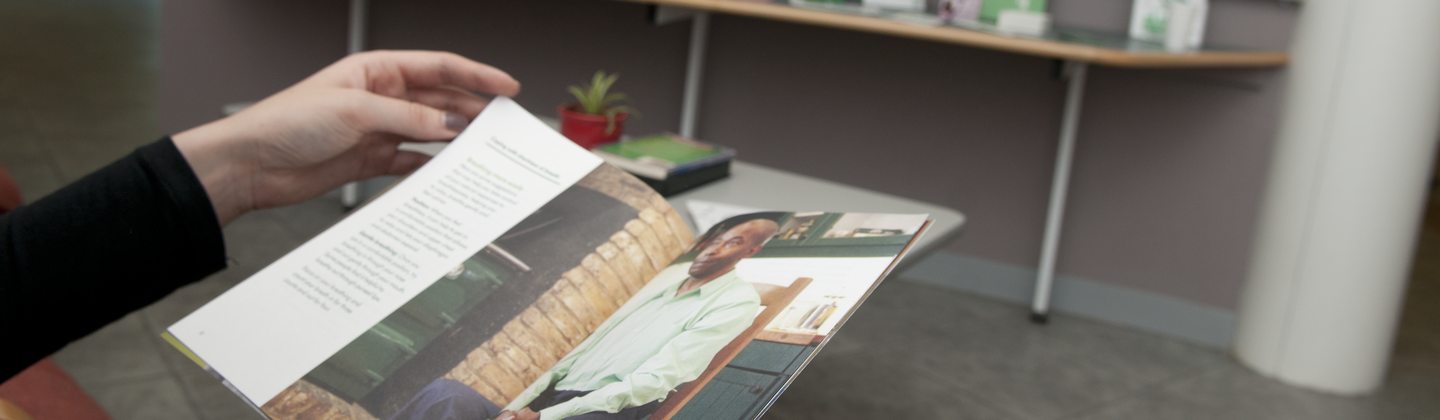 A person reading a book in a Macmillan Support Centre. 