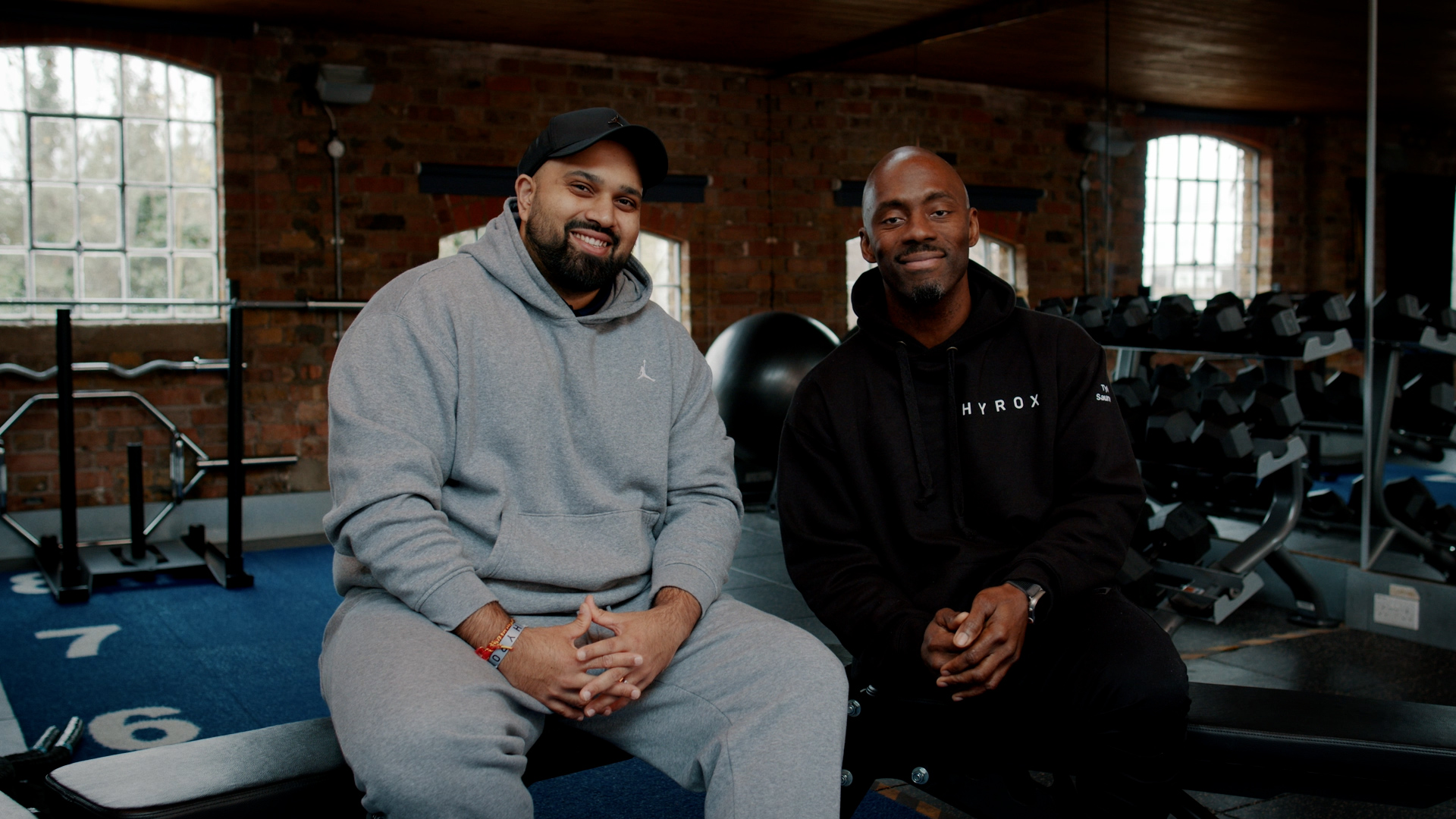 Vivek and Tyler sitting in a gym together