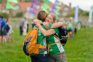 Two female hikers hug at Mighty Hikes Northumberland Coast 