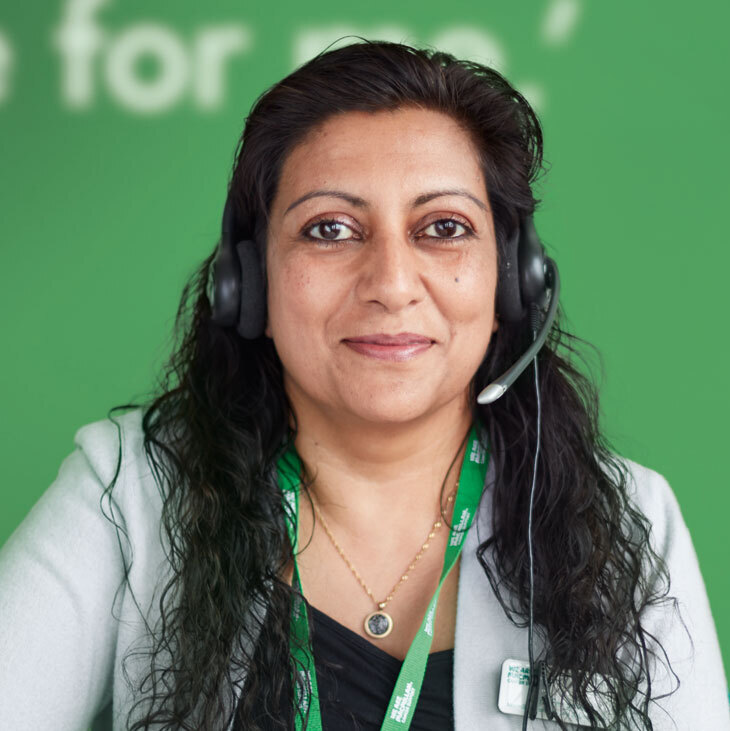 Maria, a Cancer Info & Support Officer in her 40s, wearing a headset.