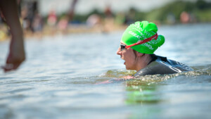 A woman wearing goggles and a wetsuit doing open water swimming