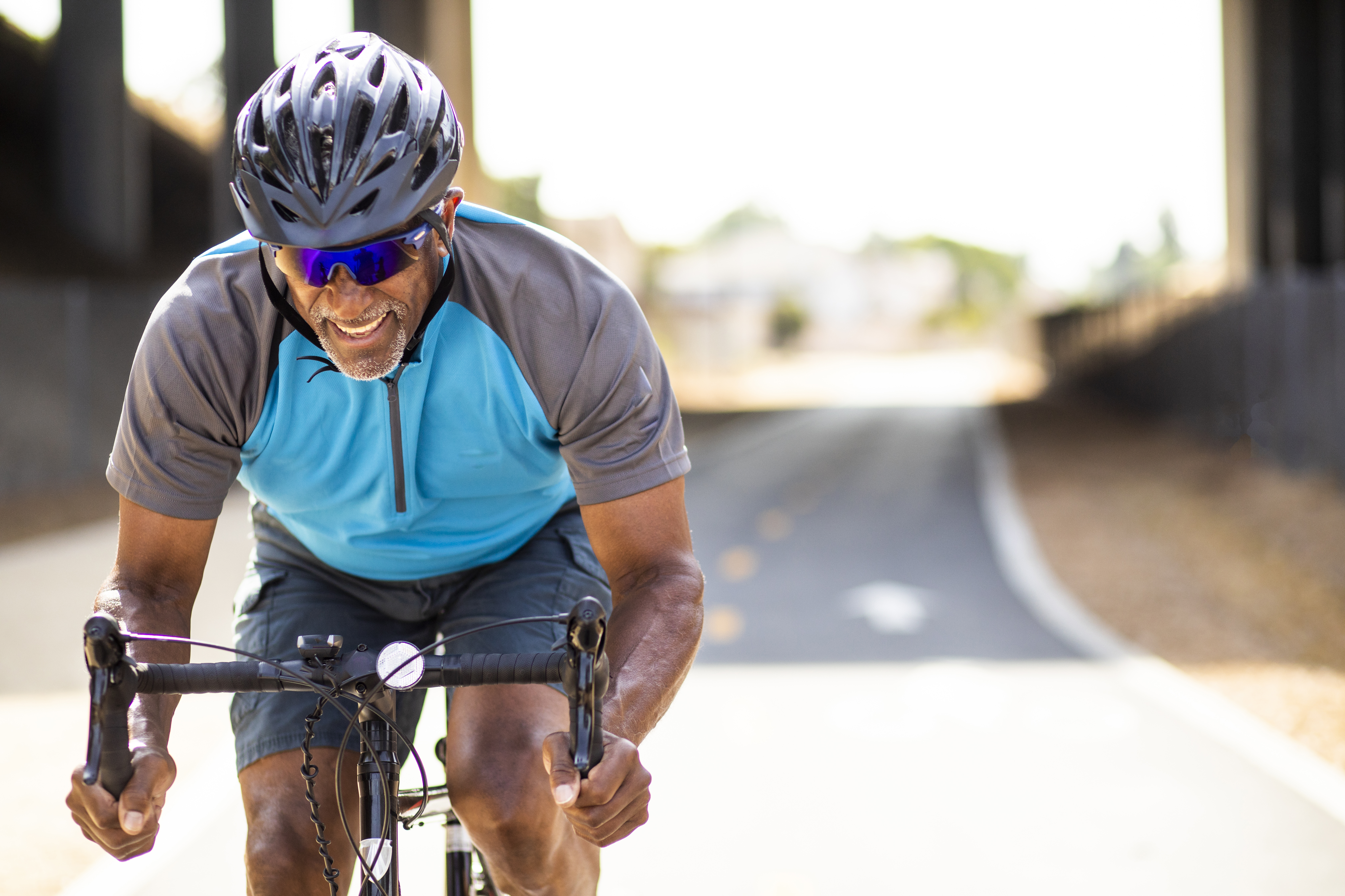Front shot of a man riding a bike on a main road.