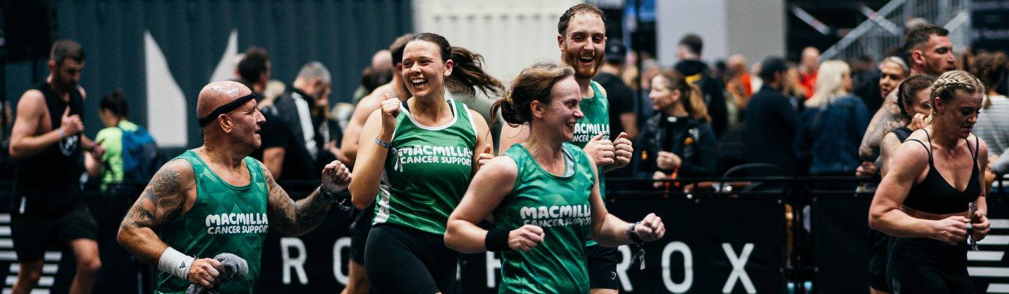 Four people wearing Macmillan vests doing a HYROX event