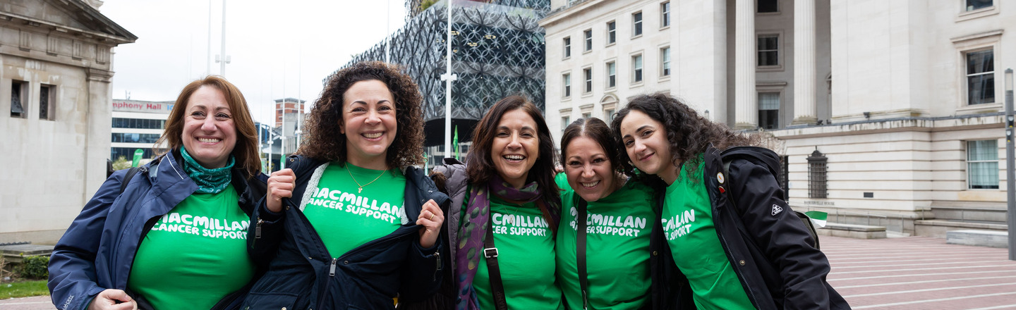 Five women wearing Macmillan t-shirts smiling at the camera