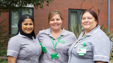 A group of three Macmillan nurses standing together.