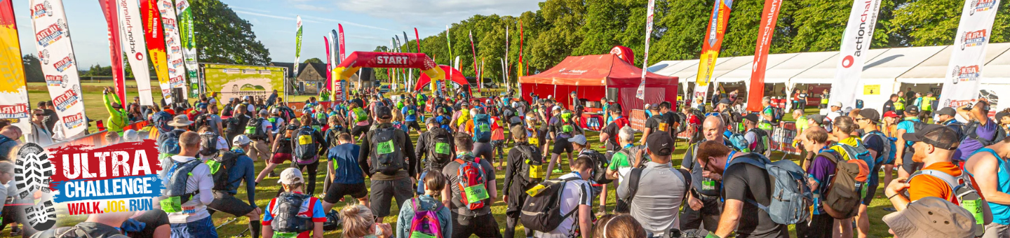 Lots of people waiting at the start of an Ultra Challenge event. A logo says Ultra Challenge Walk Jog Run.