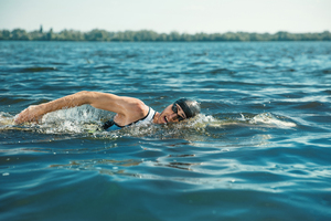 A swimmer doing front crawl in open water.