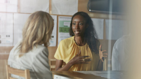 2  ladies talking sat at a table.