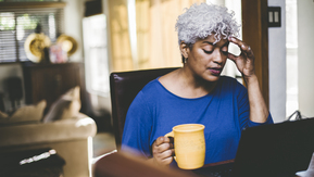 Lady sat at her computer reading.