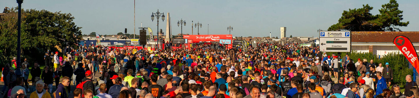 A large crowd of runners gathered to begin a race on a sunny day