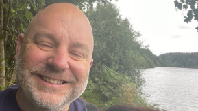 Jon is a white man with a shaved head with a beard.