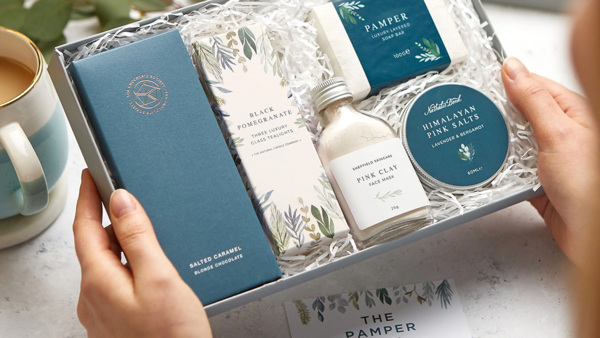 A gift box containing chocolates, candles and cosmetics