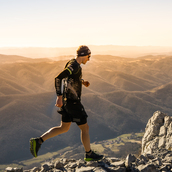 An Ultra X series competitor running on hilly, mountainous terrain.