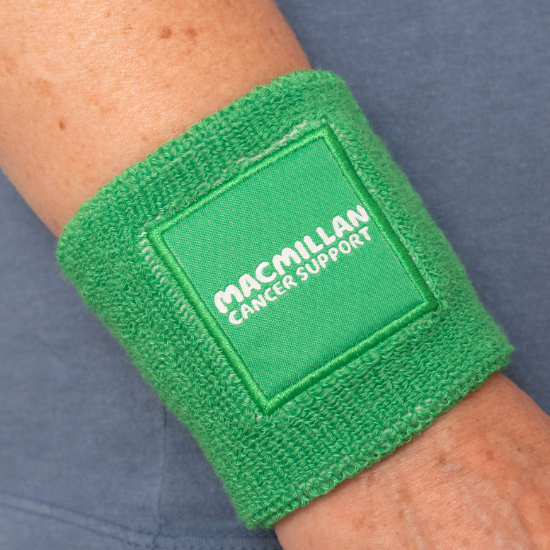 Green Macmillan Cancer Support sweat band on somebody's wrist