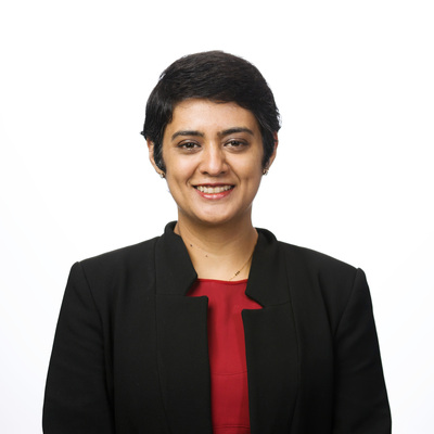 Headshot of Pahini Pandya, the CEO and Founder of Panakeia. She has short dark hair and is wearing a red top and black blazer.