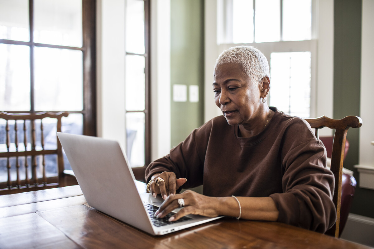 A woman sitting at a table using a laptop