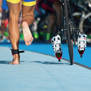 A man running alongside his bike at a triathlon.