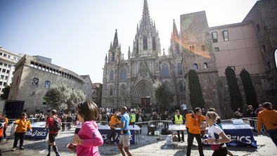 Runners taking part in the Barcelona marathon, they are wearing brightly coloured t-shirts.