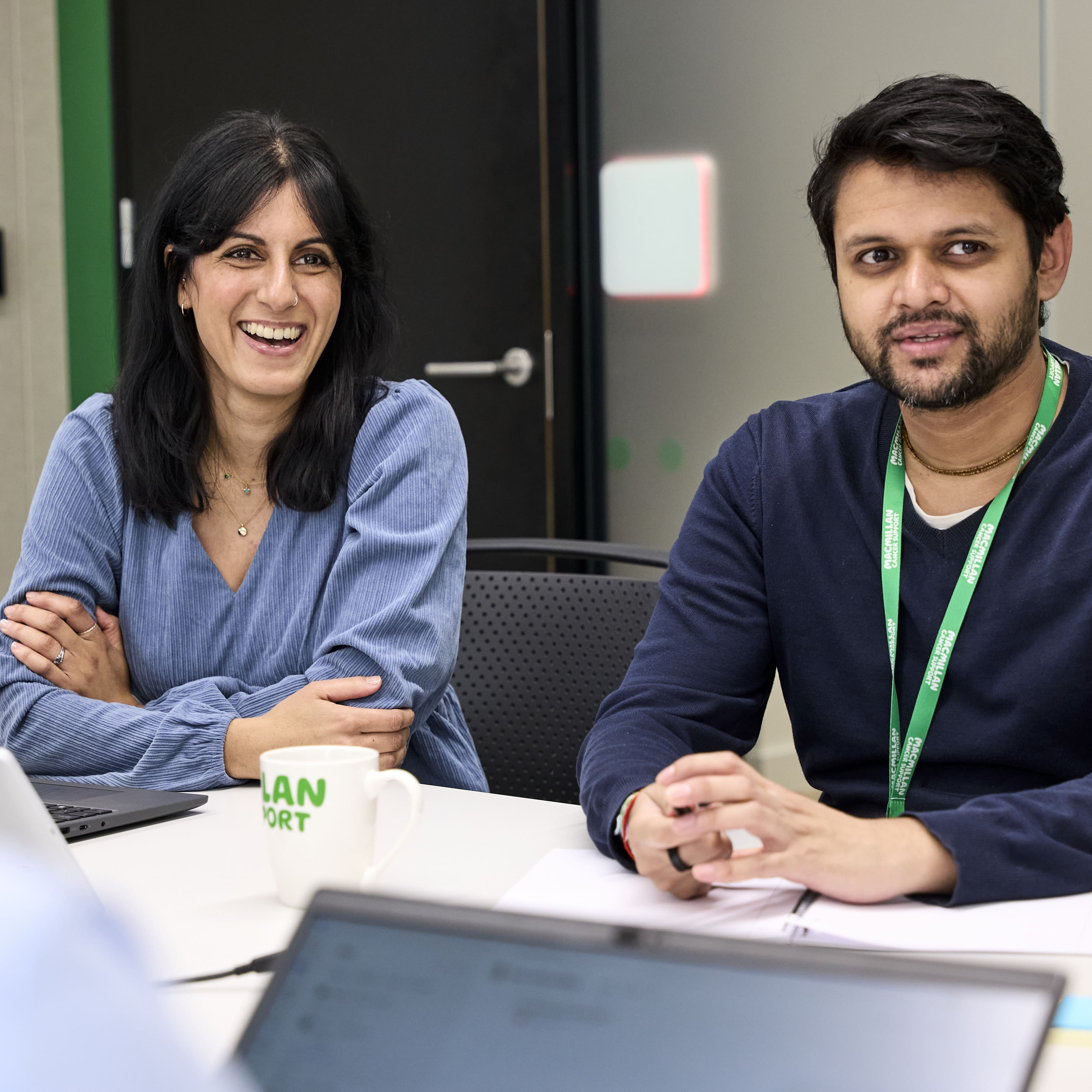 Colleagues taking part in a meeting around a table in a modern office.