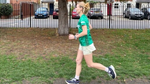 A woman in a Macmillan T-shirt running in a park.
