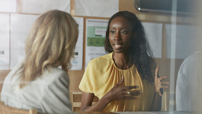 Two women sitting across from each other in conversation. 