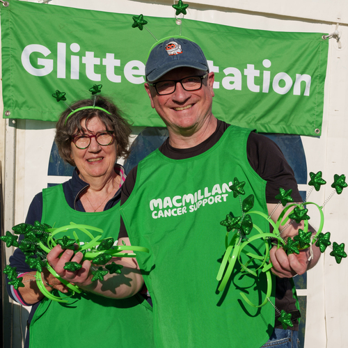 Two volunteers at a Mighty Hike are passing out celebratory green star-themed headbands.