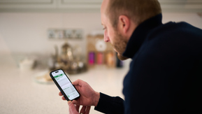 Person reading information on the Macmillan Cancer Support website on a smartphone.