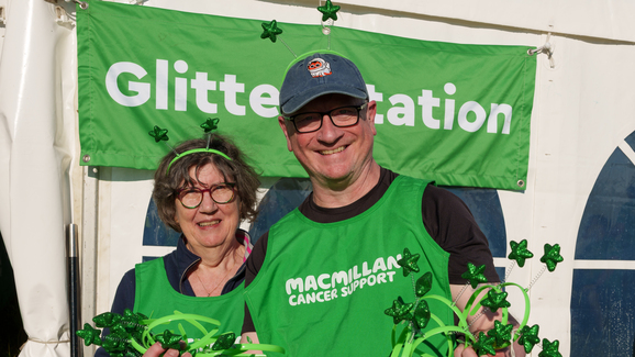 Two volunteers at a Mighty Hike are passing out celebratory green star-themed headbands.