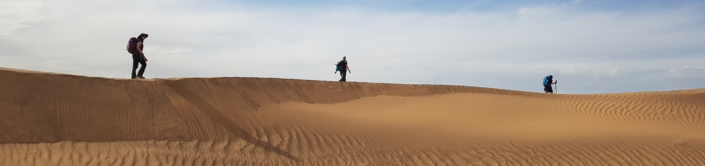 Three people hiking through the desert 