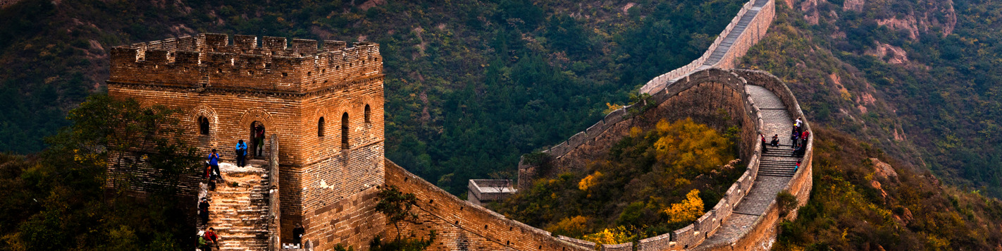 An aerial view of the Great Wall of China. It's winding through hilly train.