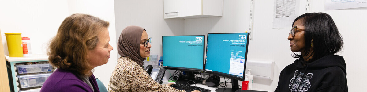 Consultant Head and Neck Therapeutic Radiographer Sabina Khan talking with a patient and another person in a consulting room