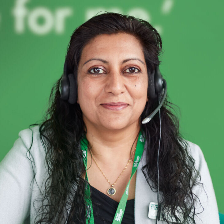 A Cancer Information Officer wearing a telephone headset ready to take a call.