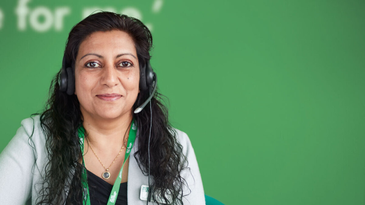 A Cancer Information Officer wearing a telephone headset ready to take a call.