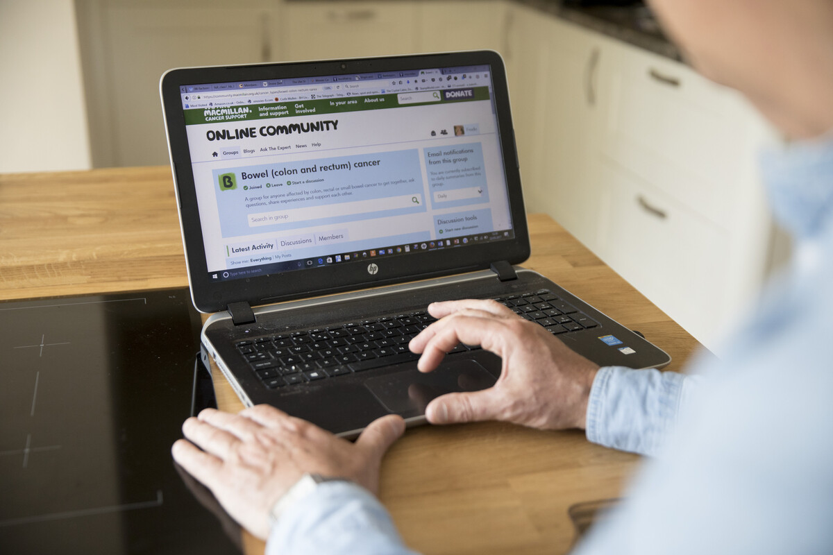 A man looking at the Online Community website from his laptop.