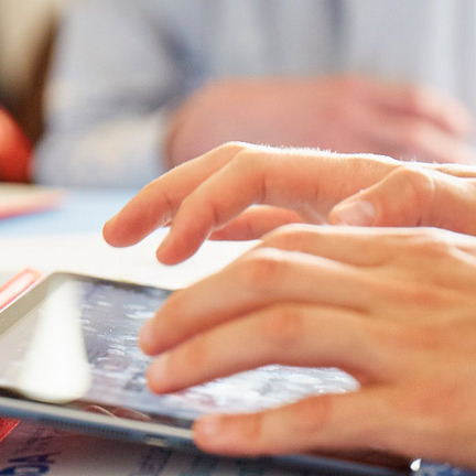 Close up image of a man's hands using an ipad.