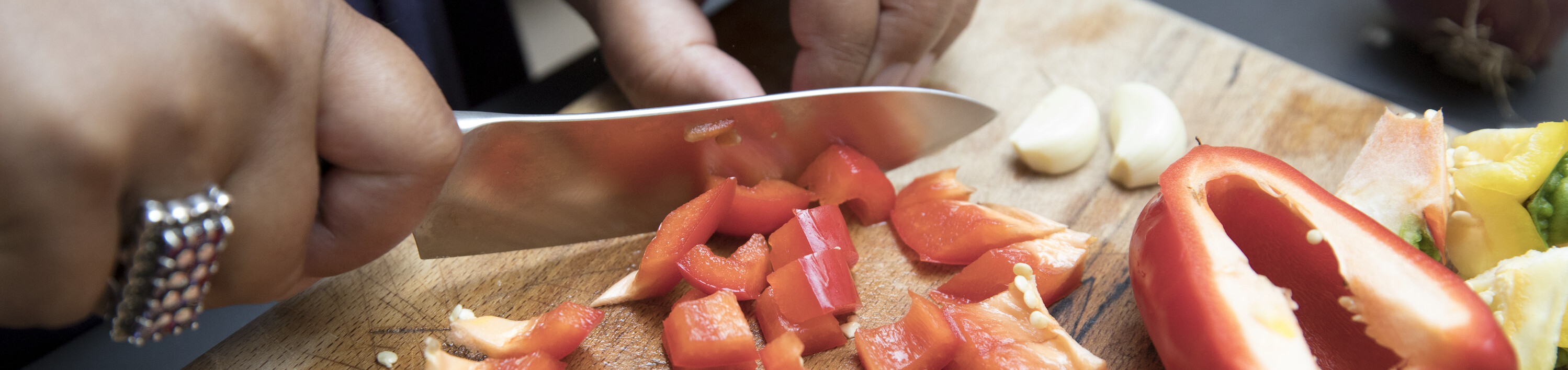 A close-up woman's hands chopping fresh vegetables