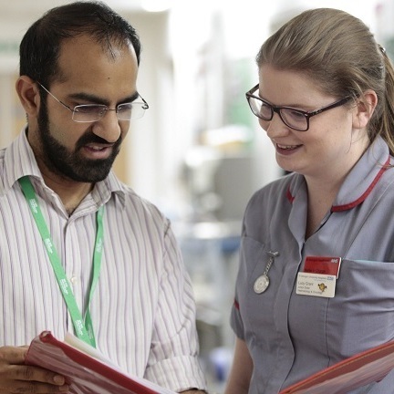 Two healthcare professionals standing in a corridor