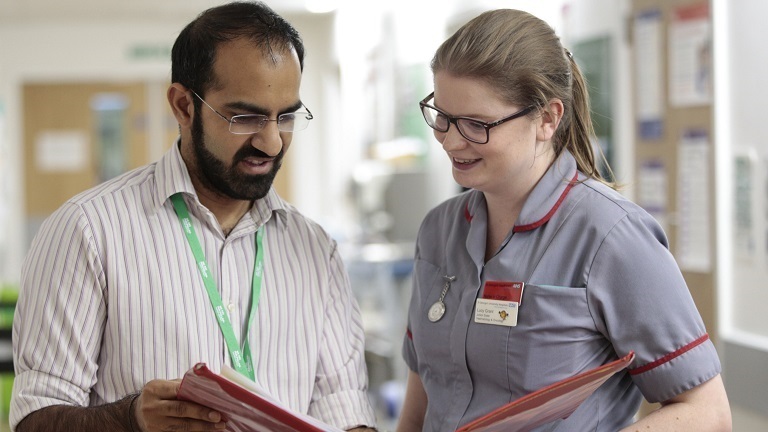 Two healthcare professionals standing in a corridor