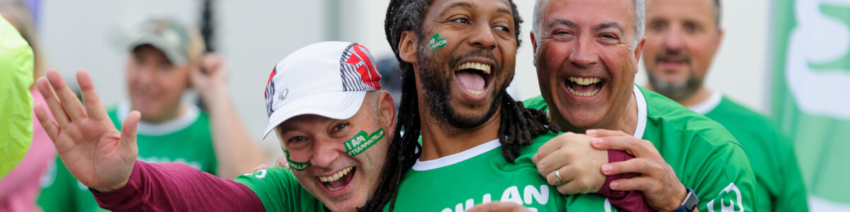 Three men laughing together at a Macmillan sporting event