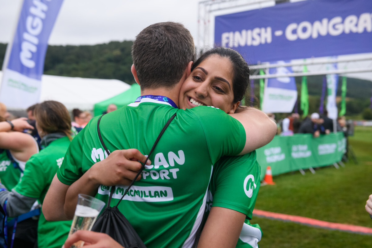 A woman hugging a man at an outdoor fundraising event.
