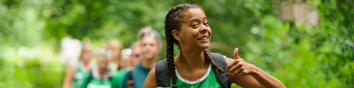 A smiling woman sticking her thumb up as a sign of positivity.