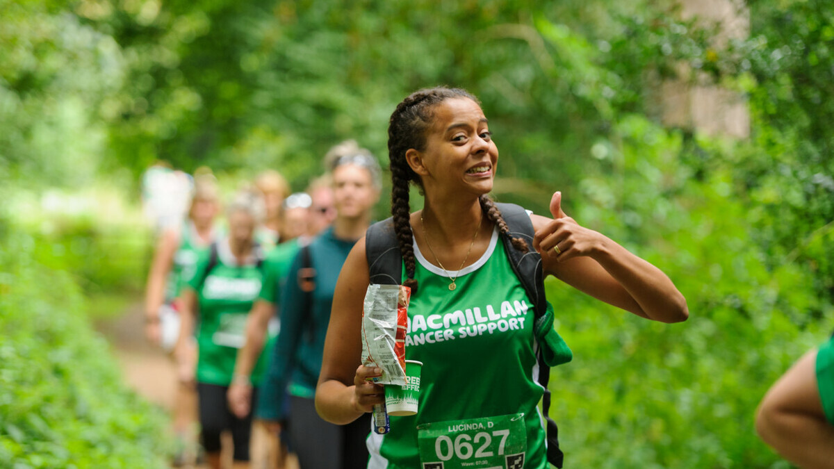 A smiling woman sticking her thumb up as a sign of positivity.