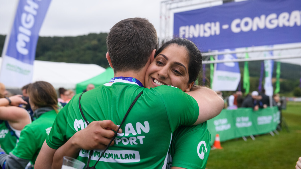 A woman hugging a man at an outdoor fundraising event.